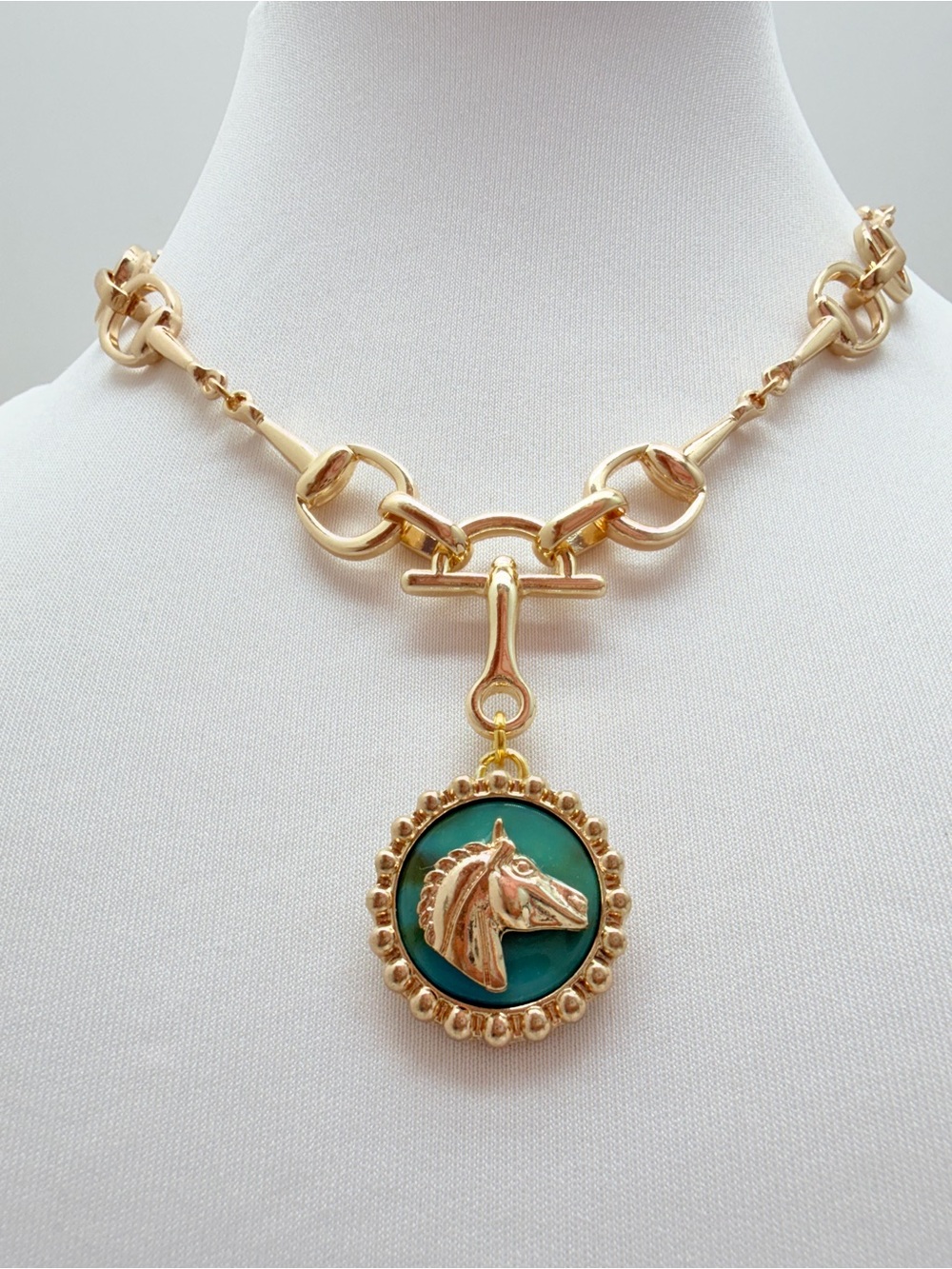 Gold horse bit necklace with turquoise background gold horse head pendant